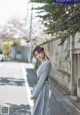 A woman in a gray dress standing on a street.