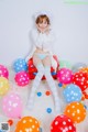 A woman sitting on top of a pile of colorful balloons.