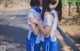 A couple of young people standing next to each other on a street.