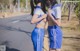 A couple of young women standing next to each other on a road.