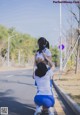 A couple of women that are standing on the side of a road.