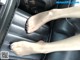 A woman's feet are sitting in the back seat of a car.