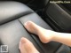 A person's foot on the back seat of a car.