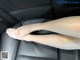 A woman's legs are sitting in the back seat of a car.