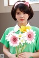 A woman holding a bunch of flowers in her hands.