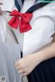 A woman in a sailor outfit with a red bow.