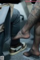 A person with a tattoo on their leg sitting in a chair.