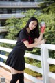 A woman in a school uniform holding a drink.