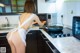 A woman in a white dress is cooking in a kitchen.