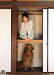 A woman sitting in a doorway with a dog.