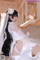 A woman in a wedding dress sitting on a couch.