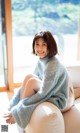 A woman sitting on top of a white bean bag chair.