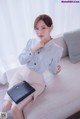 a woman sitting on a couch holding a black purse