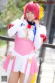 A woman in a pink and white outfit posing for a picture.