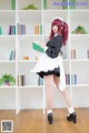 A woman in a maid outfit holding a book.