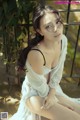 A woman in a white dress sitting on a bench.