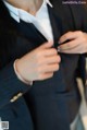 A man in a suit adjusting his tie. 