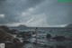 A woman standing in the middle of a body of water.