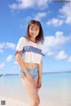 A woman standing on a beach next to the ocean.