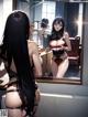 A woman in lingerie looking at herself in the mirror.