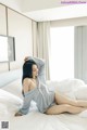 A woman sitting on a bed in a bedroom.