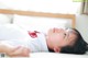 A woman laying on a bed with a red bow tie.