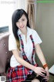 A woman in a school uniform sitting on a chair.