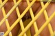 A close up of a man's penis behind a yellow fence.