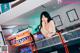 A woman sitting at a video game machine in a room.